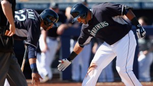 PEORIA, AZ - MARCH 05:  Nelson Cruz #23 (R) of the Seattle Mariners low fives Robinson Cano #22 at home plate after Cruz hit a two run home-run against the San Diego Padres during the third inning of the spring training game at Peoria Stadium on March 5, 2015 in Peoria, Arizona.  (Photo by Christian Petersen/Getty Images)
