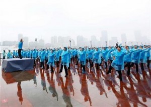 En esta imagen, tomada el 21 de mayo de 2016, mujeres equipadas con chubasqueros bailan al unísono en el Bund en Shangai. Según el cibersitio Guinness World Records, 31.697 personas en Beijing, Shangai y cuatro ciudades más establecieron un nuevo récord mundial de baile en múltiples localizaciones al ejecutar una coreografía sincronizada juntas durante más de cinco minutos. (Chinatopix via AP) CHINA OUT